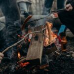 Selective Focus Photography of People Holding Sticks With Sausages