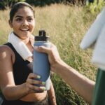 Happy Woman Holding Water Bottle at Workout