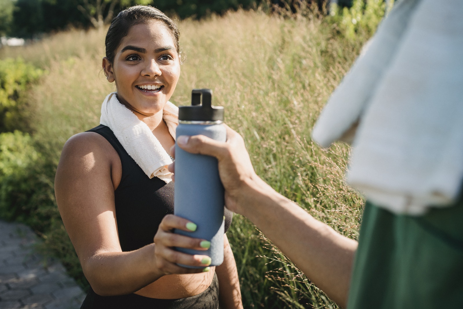 Happy Woman Holding Water Bottle at Workout