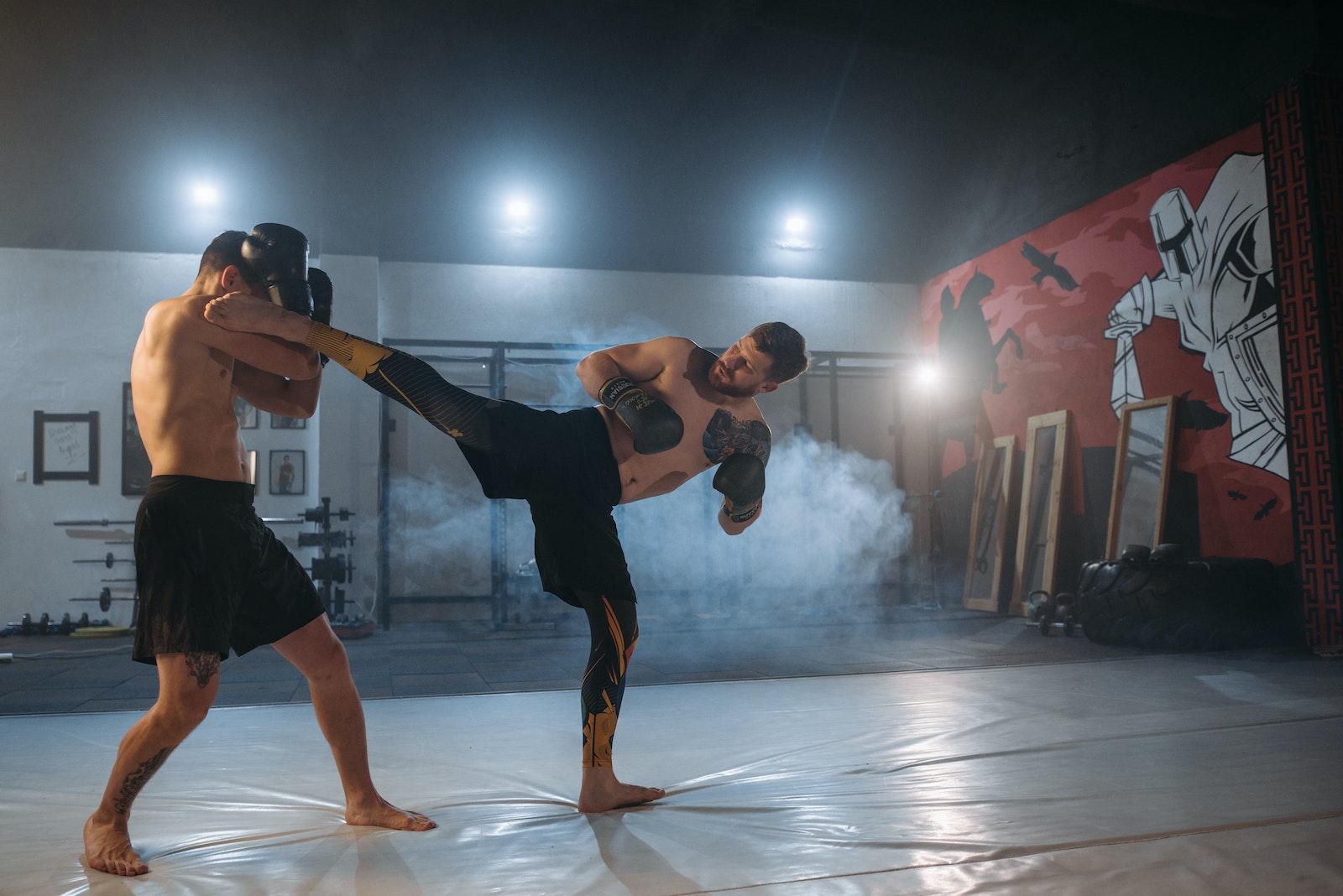 A Shirtless Man Blocking His Opponent's Kick