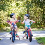 girl in pink tank top riding on bicycle during daytime