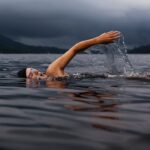 man swimming on body of water