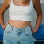 woman in white tank top and blue denim jeans