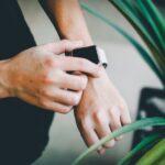 person about to use silver Apple Watch in grey Sports Band