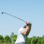 man in white tank top and white shorts playing golf during daytime